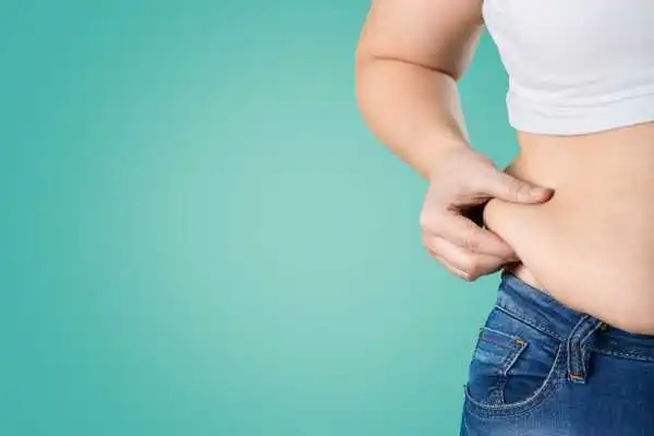 Image of woman pinching her love handles to show weight gain Govan
